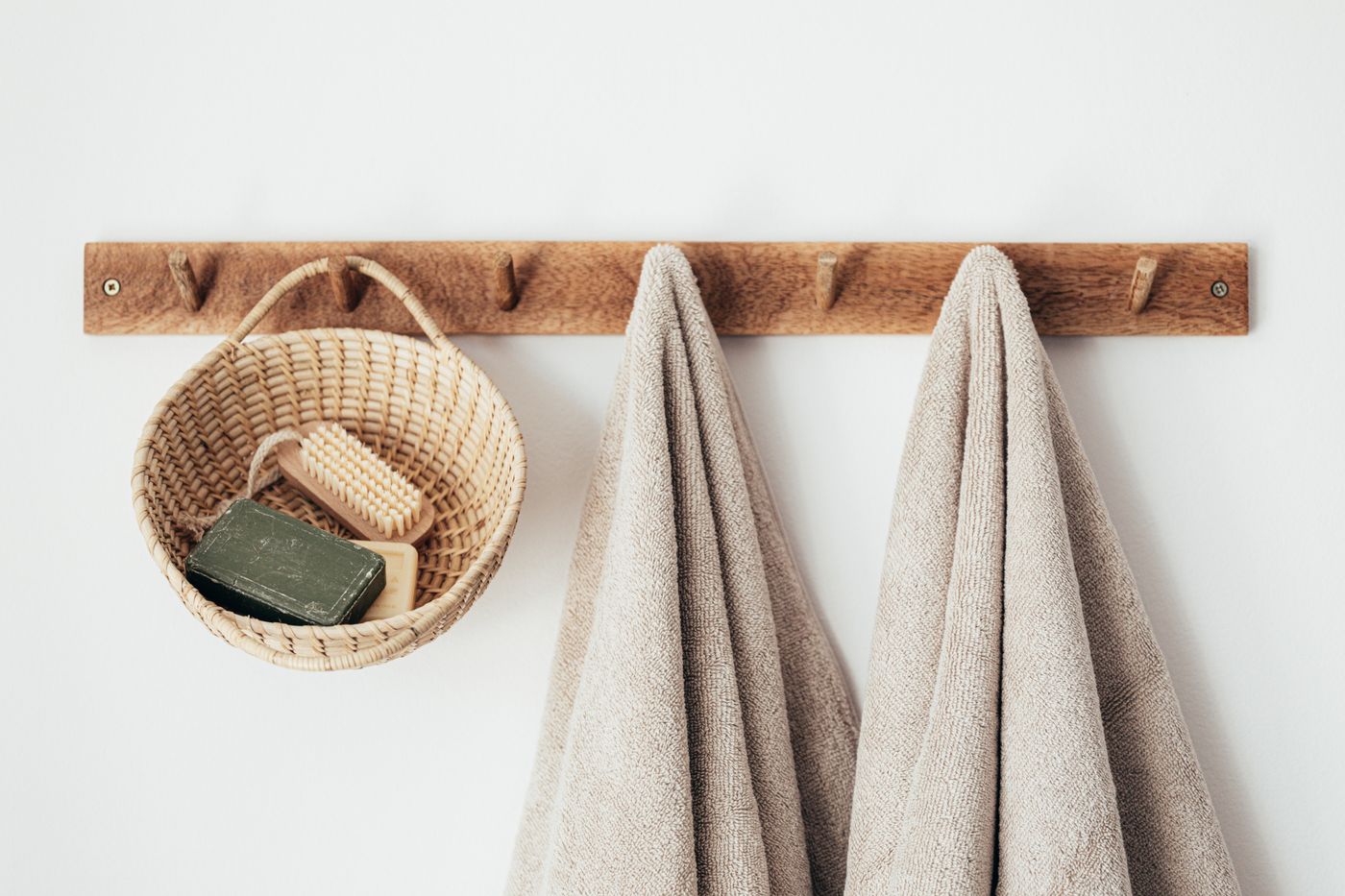 Fresh folded towels and a basket of soap on a rack