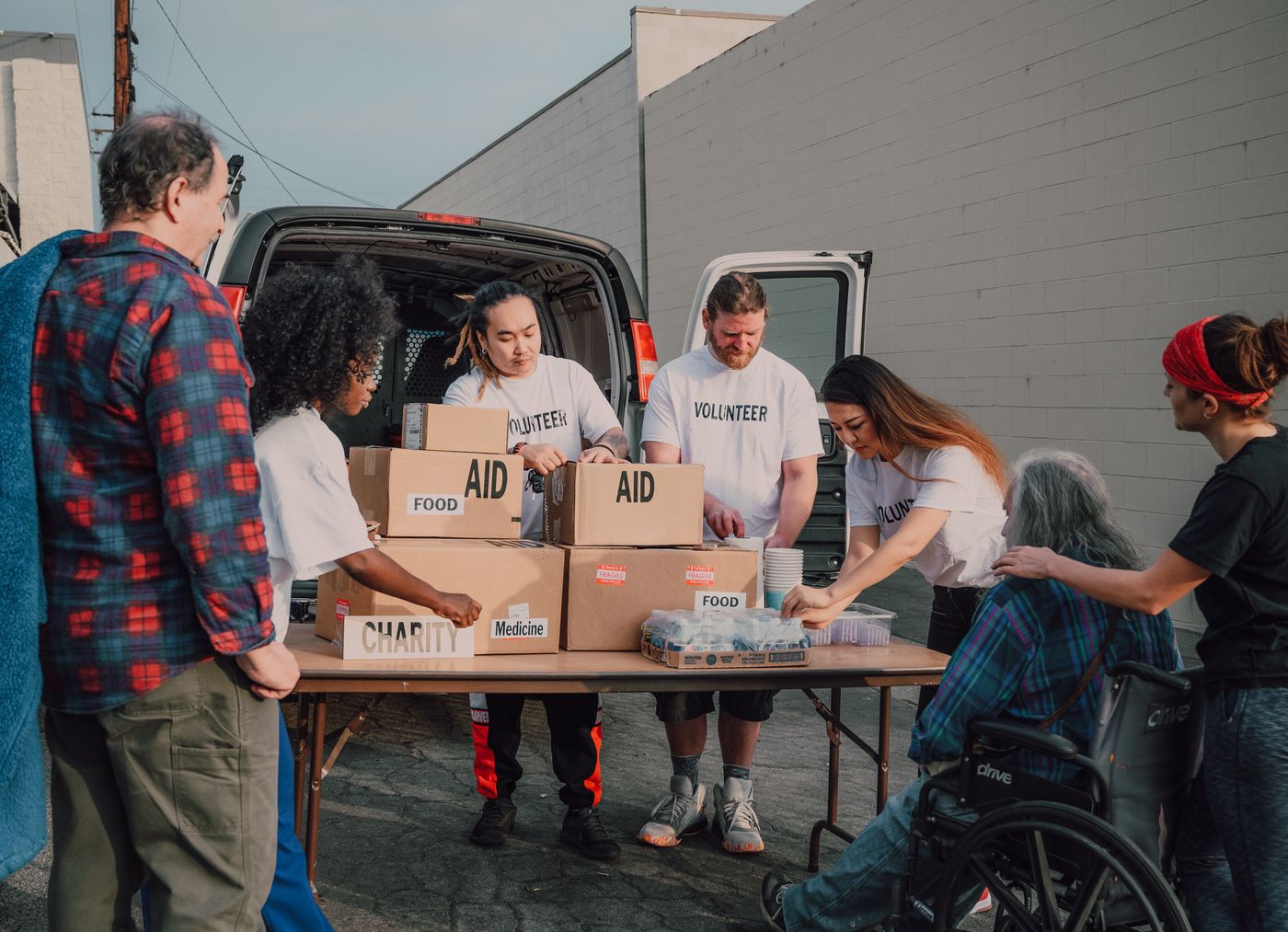 Volunteers unloading aid supplies from a van at a community outreach event